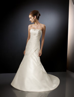 Bridal Dress: Angelina Faccenda: 1071 - Silk Shantung  Seed pearls and crystals edge the contoured strapless neckline with asymmetrical draping crossing over the bodice and cascading onto the skirt to create the fit and flared shape. Draping onto the chapel length train surrounds the corset tie back. Color: Ivory 