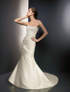 Bridal Dress: Angelina Faccenda: 1072 - Silk Shantung  Crystal beading is sprinkled onto the strapless neckline that meets the contoured empire. Draping cascades over the body and crosses over to shape the fit and flare gown with a chapel length train. Color: Ivory 