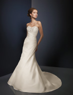 Bridal Dress: Angelina Faccenda: 1076 - Silk Shantung  Jeweled beading frames the sweetheart strapless neckline with cross over draping overlaying the bodice. Asymmetrical draping continues onto the slim A-line skirt with buttons cascading down the chapel length train. Color: Ivory 