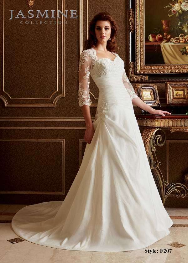 Bridal Dress: COLLECTION BRIDAL - F207  Catalogue Color:  IVORY (IV)  Silhouette:  Queen Anne neckline with sheer 3/4 sleeves. Keyhole opening on the back of the dress with covered buttons all the way down to end of train. Pleated bodice below the empire waist.  Fabric-top layer:  TAFFETA and NETTING  Accessory:  N/A  Skirt Length:  Chapel Train  Size Range:   4-28  