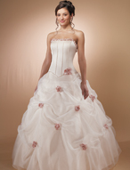 Quinceanera Dress: MoriLee - 86007  Rosettes edge the scooped, strapless neckline on the boned, corset bodice with basque waistline, and corset tie back closure.  The full skirt features ruched pick ups with roses tucked in and a flounced hemline.  Matching shawl edged with rosettes is included.
Color Availability:  Champagne/Blush, White/Pink 