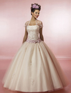 Quinceanera Dress: Quinceanera/Vizcaya: 81003 Tulle and Duc  The strapless bodice features beaded embroidery with a draped sash hugging the hips. Scattered appliques enhance the tulle ball gown skirt. Front and back bows and a matching bolero jacket. Color Availability: Champagne/Blush, Gold, Iris 