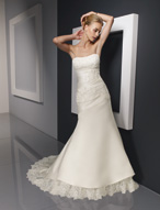 Bridal Dress: Bridals: 2316 - Duchess Satin with Lace  Alencon lace is appliqued onto the strapless bodice with asymmetrical draping from the empire over the fitted torso with a corset tie back. The slim, A-line skirt is trimmed with a scalloped lace flounce surrounding the hemline and chapel length train. Available in 3 Lengths 55