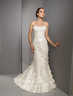 Bridal Dress: Blu: 4516 - Luxe Taffeta with Embroidere  Beaded embroidery overlays the strapless bodice with asymmetrical tiers forming the fit and flared gown with a corset tie back and chapel length train. Available in 3 Lengths 55