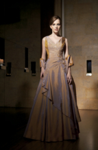 Bridesmaids Dress: JADE - J1182  Catalogue Color :  GOLD (GD)Silhouette :  Jade Silk Dupioni gown has V front and back shirred bodice. Front bodice has beaded lace detailing and at side drop waist. A-line full skirt with side ruffle; comes with matching wrap.Fabric-top layer :  SILK DUPIONIGown or 2 piece :  DressJacket :  Front Neckline :  VBack Neckline :  VFront Bodice Detail :  Beaded lace and gatheredBack Bodice Detail :  GatheredSleeve :  Gown :  Belt or Sash Detail :  N/AWaist :  DropFront Skirt Detail : PlainBack Skirt Detail :  PlainFront Hem Detail :  PlainBack Hem Detail :  PlainAccessory :  ShawlSkirt Length :  FloorSize Range :  2-26 