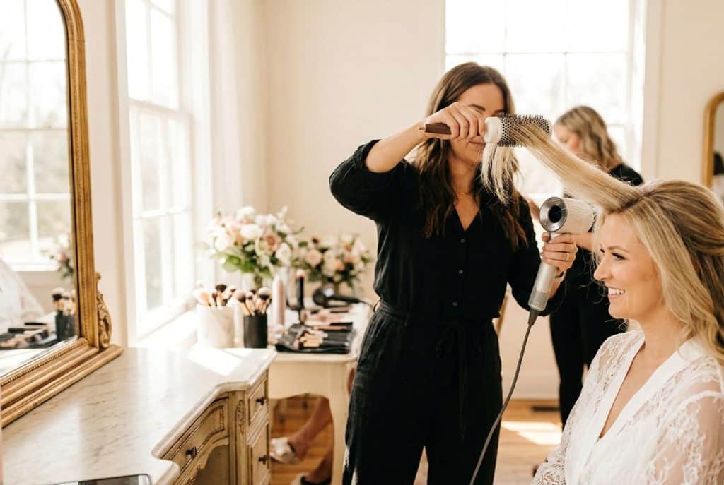_hair-stylist-drying-client_s-hair-in-a-sunlit-room_